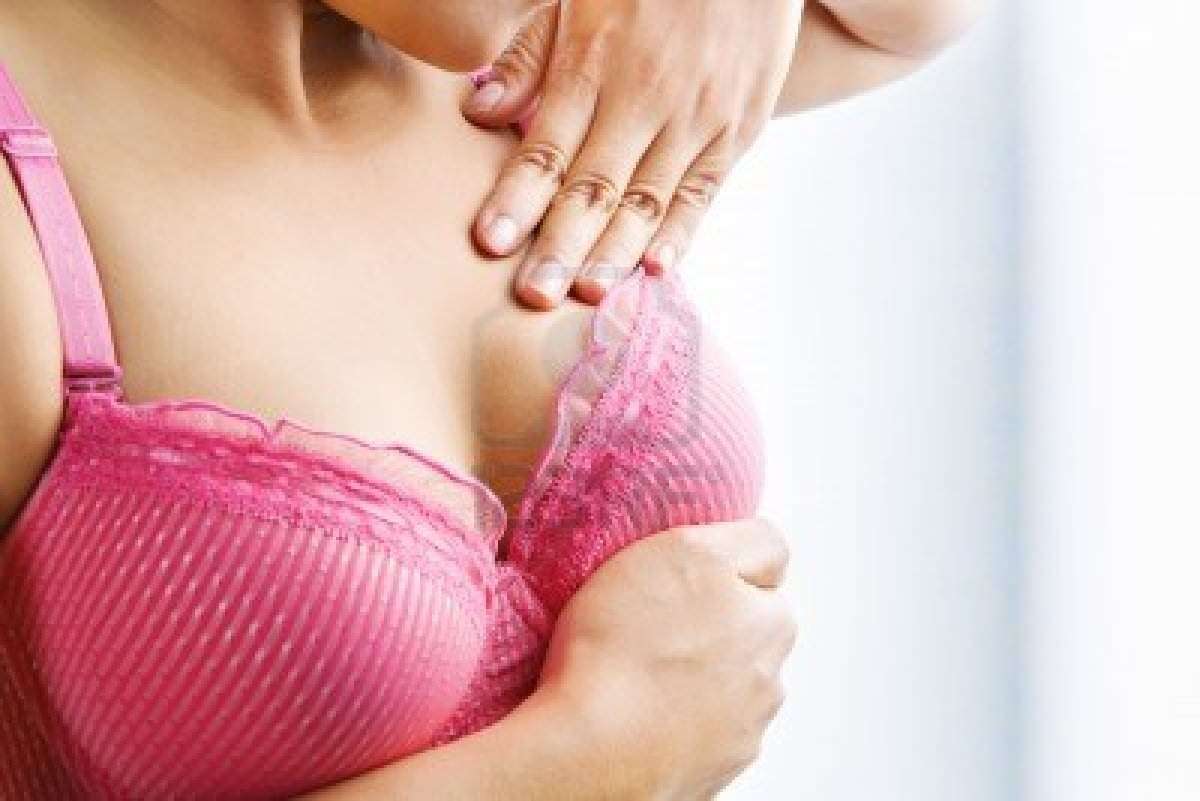 5678505-woman-doing-self-breast-examination-using-pink-bra